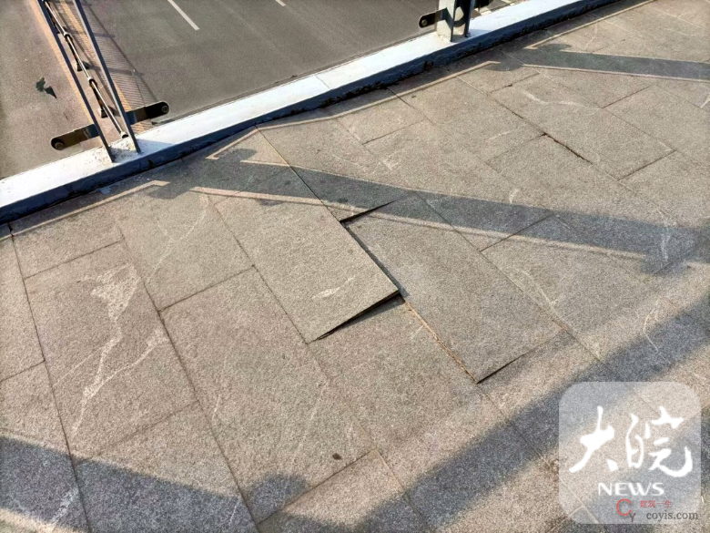 云谷路人行天桥的桥面有地砖拱起